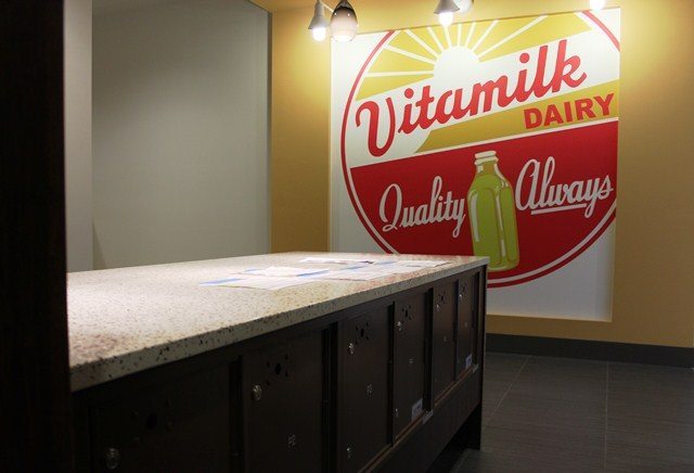 A large Vitamilk Dairy poster hangs in the mail room of Green Lake Village